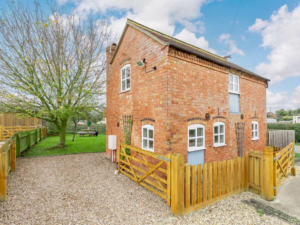 a red brick house with a wooden fence at 1 bed in Ledbury 90349 in Eldersfield