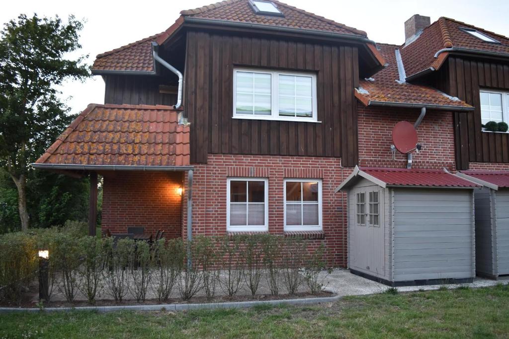 a house with a brown roof and a garage at Ferienwohnung - Unsere Wenke in Lemkendorf
