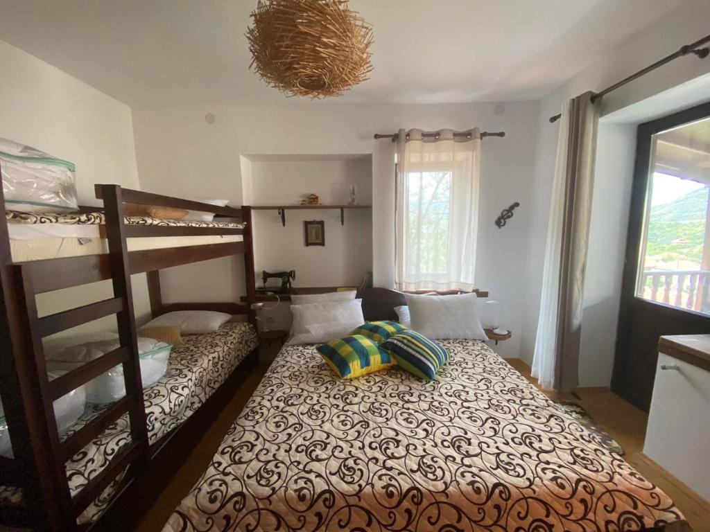 een slaapkamer met een stapelbed en een bed met een kussen bij Каменната къща in Borovo