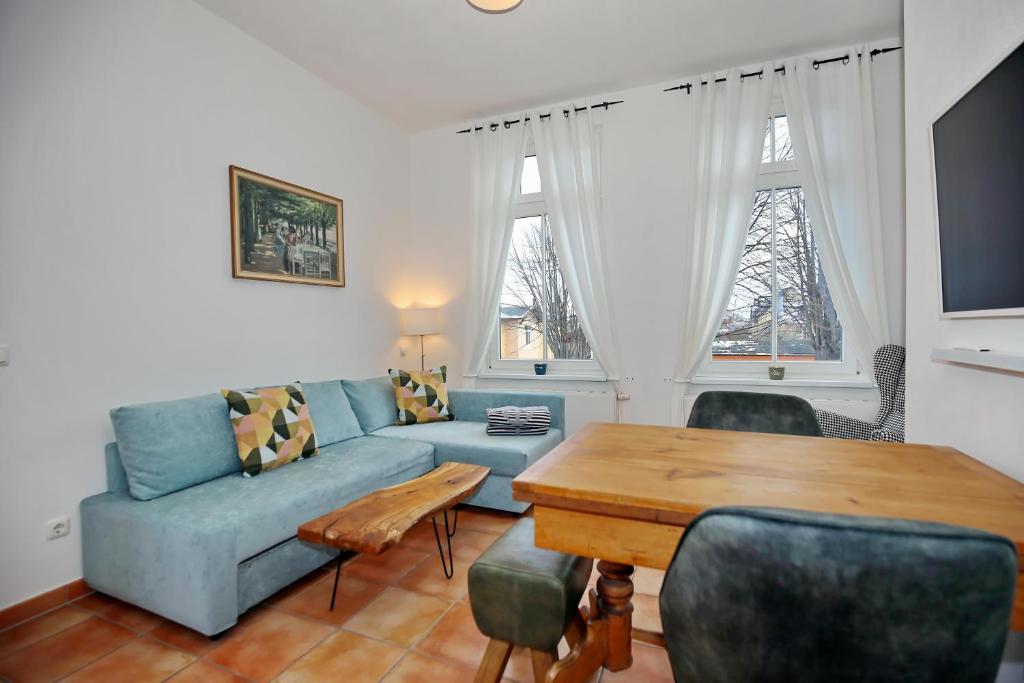 uma sala de estar com um sofá azul e uma mesa em Strandstraße 16 Wohnung 09 em Kühlungsborn