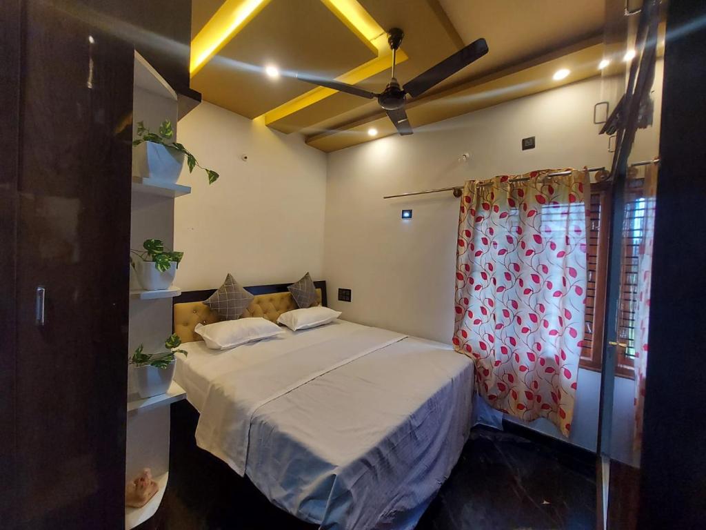 a bedroom with a bed and a ceiling fan at freedome at homestay in Chāmundi