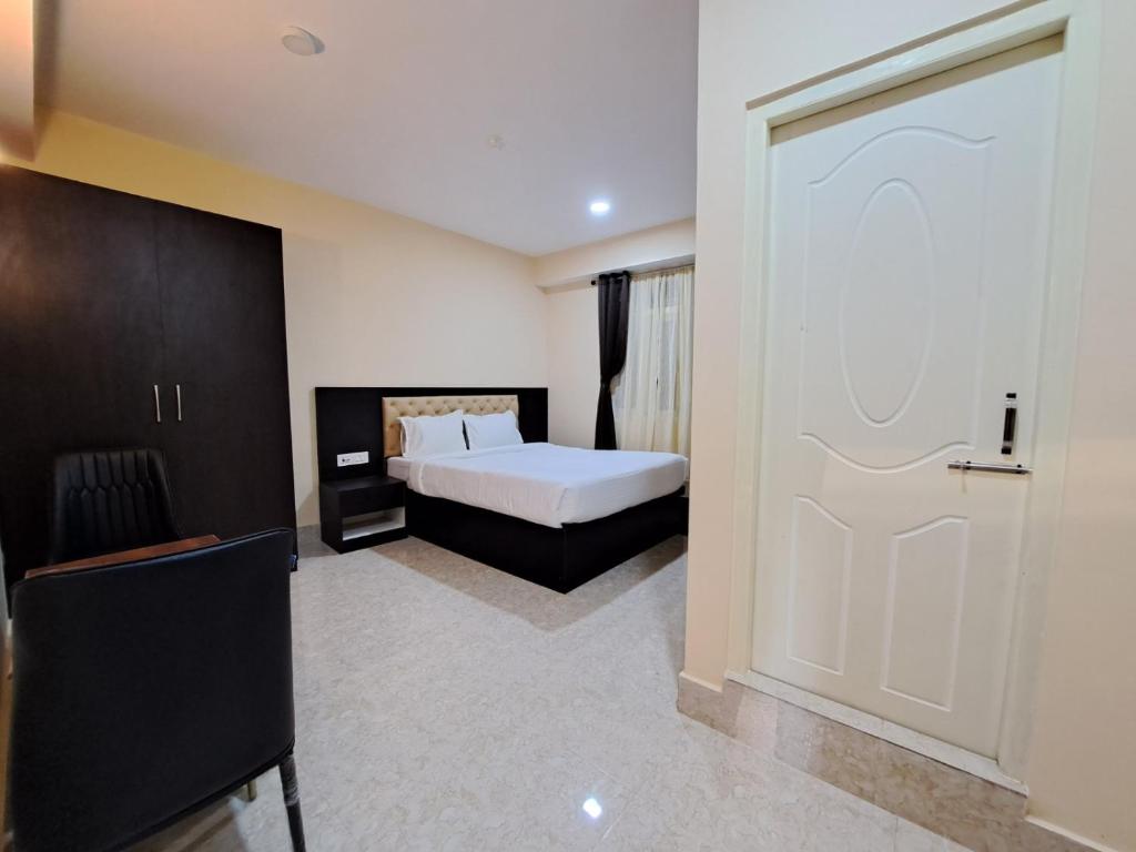 een slaapkamer met een wit bed en een deur bij Snow White Retreat Hotel& Restaurant in Gangtok