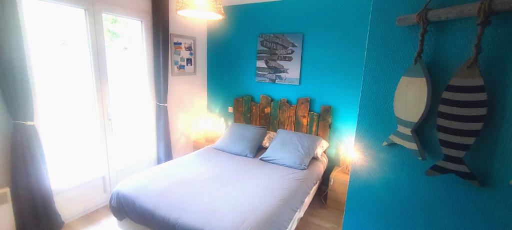 1 dormitorio con una pared azul y 1 cama en EntreLac&Océan chambre d'hôtes chez l'habitant 2, cyclotouriste bienvenue, en Aureilhan