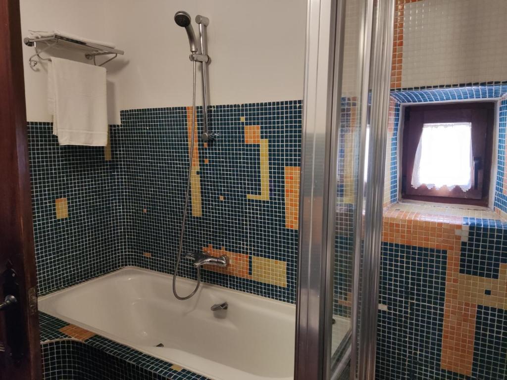 a bathroom with a tub and a shower with a window at Casa del Arte in Simancas