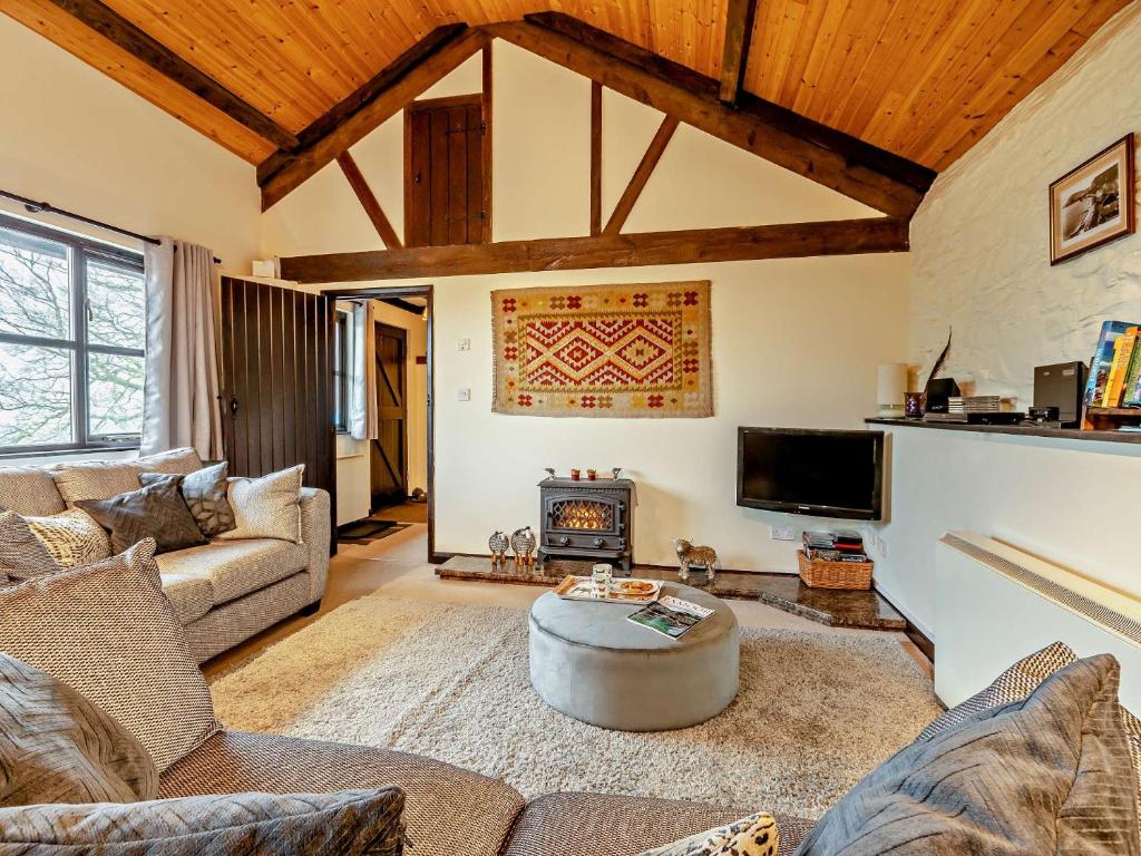 sala de estar con sofá, mesa y chimenea en 2 Bed in Dulverton 90558, en Dulverton
