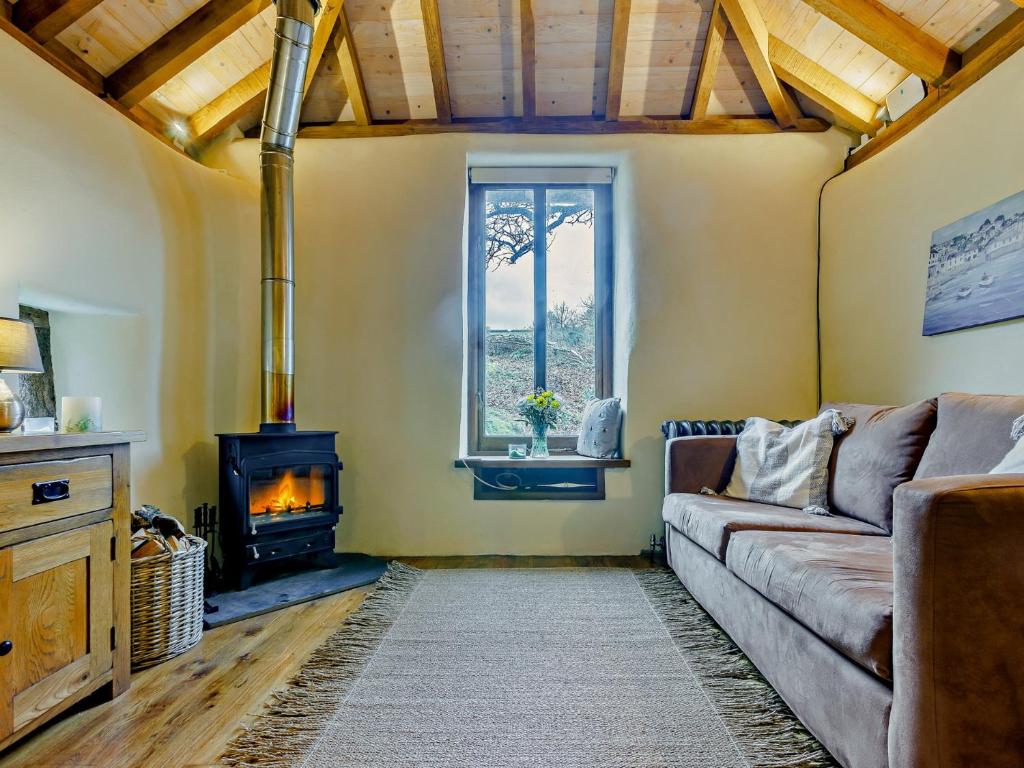 a living room with a couch and a wood stove at 1 Bed in Tiverton 90656 in Washfield