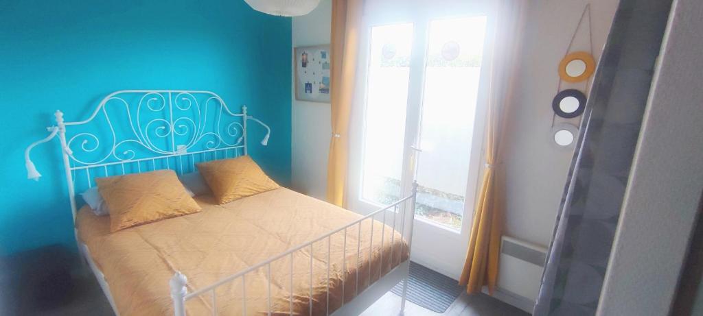1 dormitorio con 1 cama con pared azul en EntreLac&Océan chambre d'hôtes chez l'habitant 1, cyclotouriste bienvenue, en Aureilhan