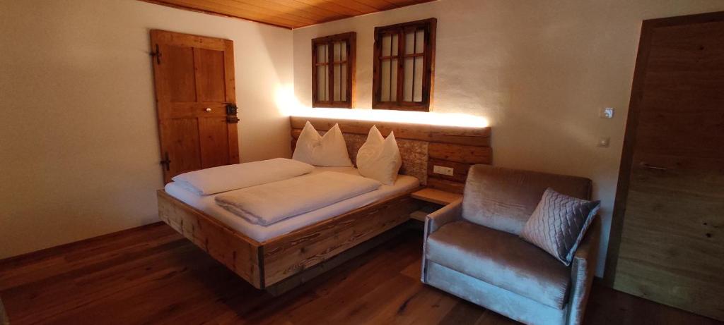 een kleine slaapkamer met een bed en een stoel bij Innerraderhof in Prato alla Drava