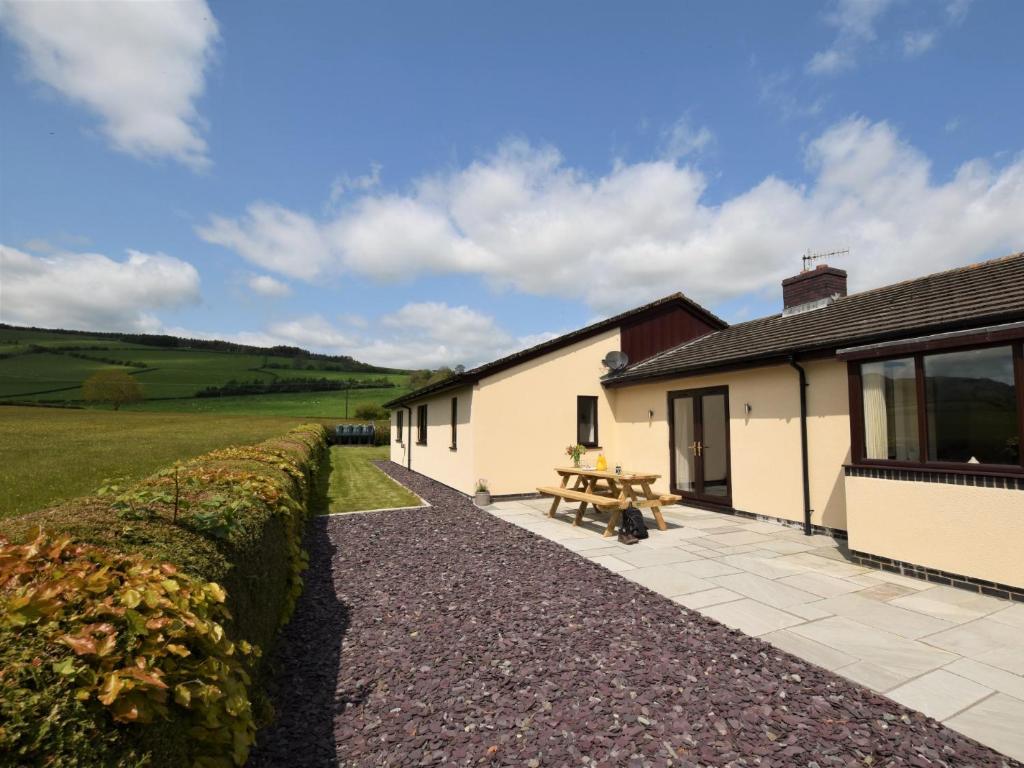 a cottage with a picnic table outside of it at 3 Bed in Kington 90768 in Kinnerton