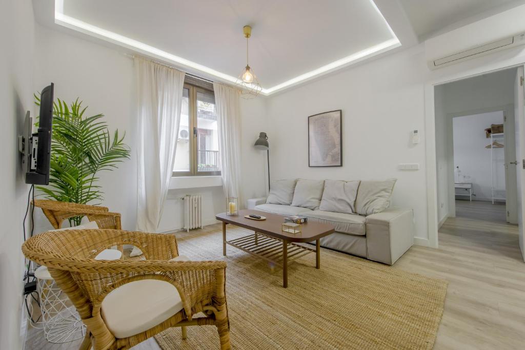 un soggiorno con divano e tavolo di Elegante apartamento en el Centro de Madrid-Rastro a Madrid