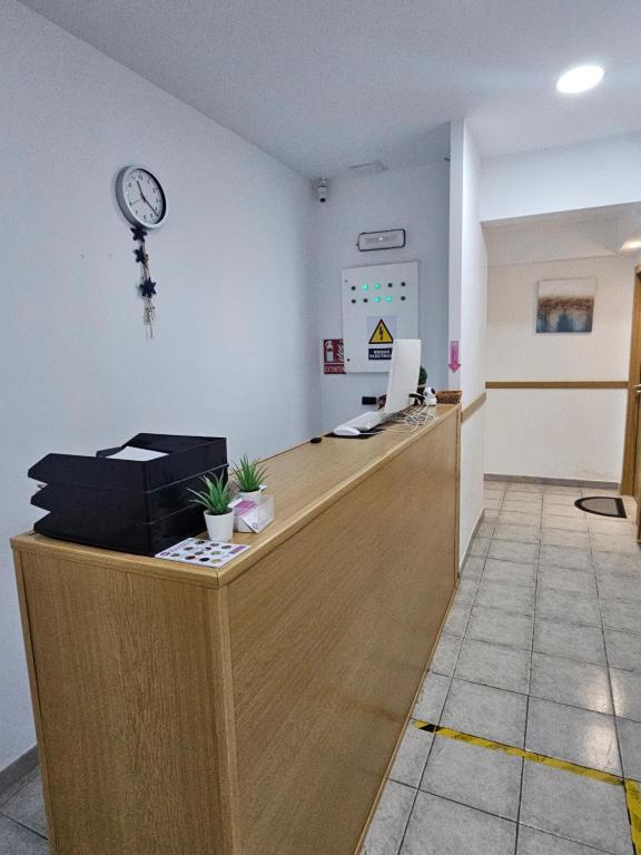 un bureau avec une réception avec une horloge sur le mur dans l'établissement MHrosa, à Valence