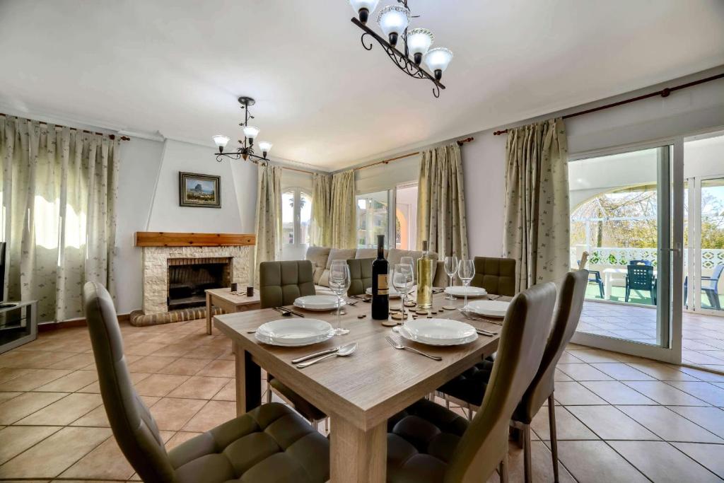 a dining room with a table and a fireplace at Villa Alaska - PlusHolidays in Calpe