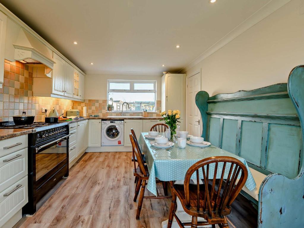 uma cozinha com mesa e cadeiras e uma cozinha com fogão em 3 Bed in Bembridge 90582 em Bembridge