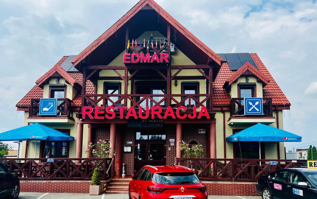 a red car parked in front of a restaurant at EdMar in Malbork