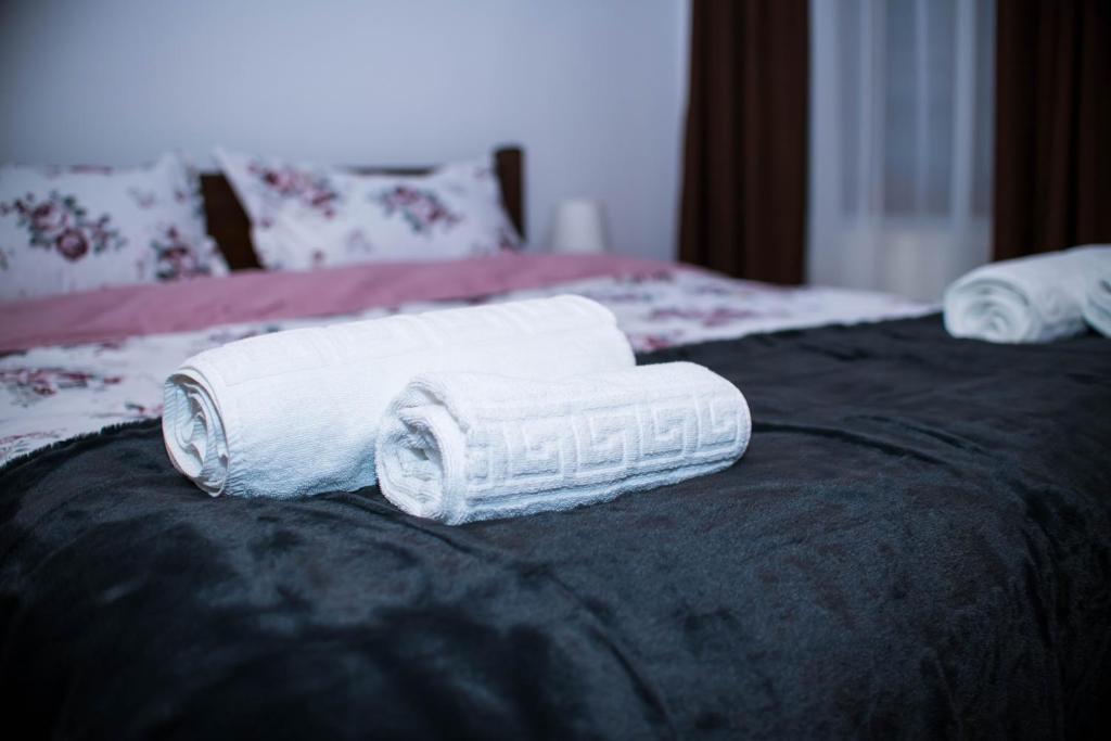 two rolled towels sitting on top of a bed at Studio Sonia - Tordosan Central - #3 in Sibiu