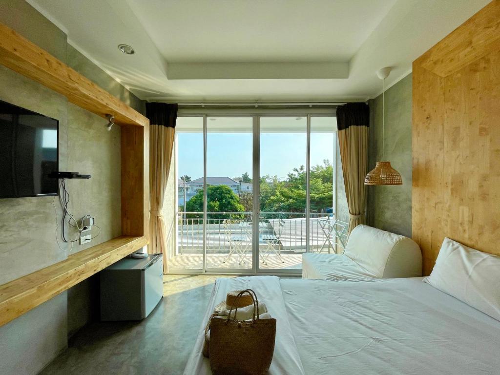 um quarto com uma cama e uma grande janela em Check-in Resort Koh Larn em Ko Larn