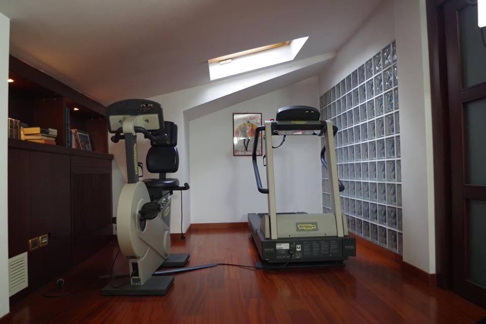 a room with a gym with a treadmill and a mirror at B&B Independente in Assago