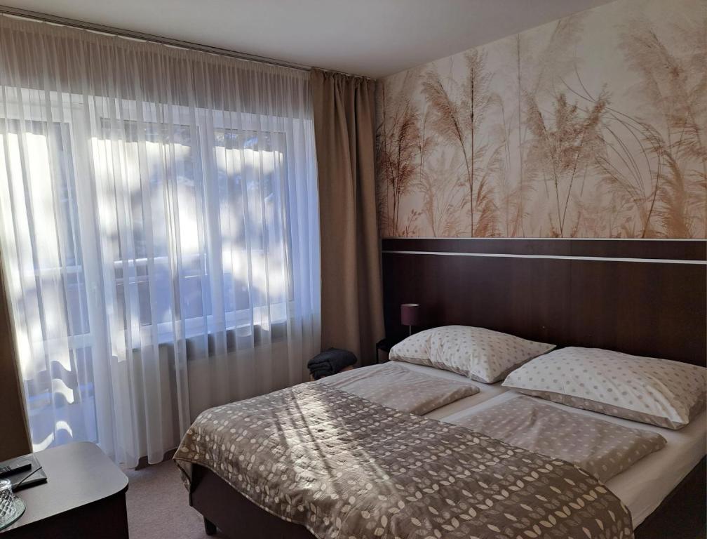 a bedroom with a bed and a large window at Willa Celina in Karpacz