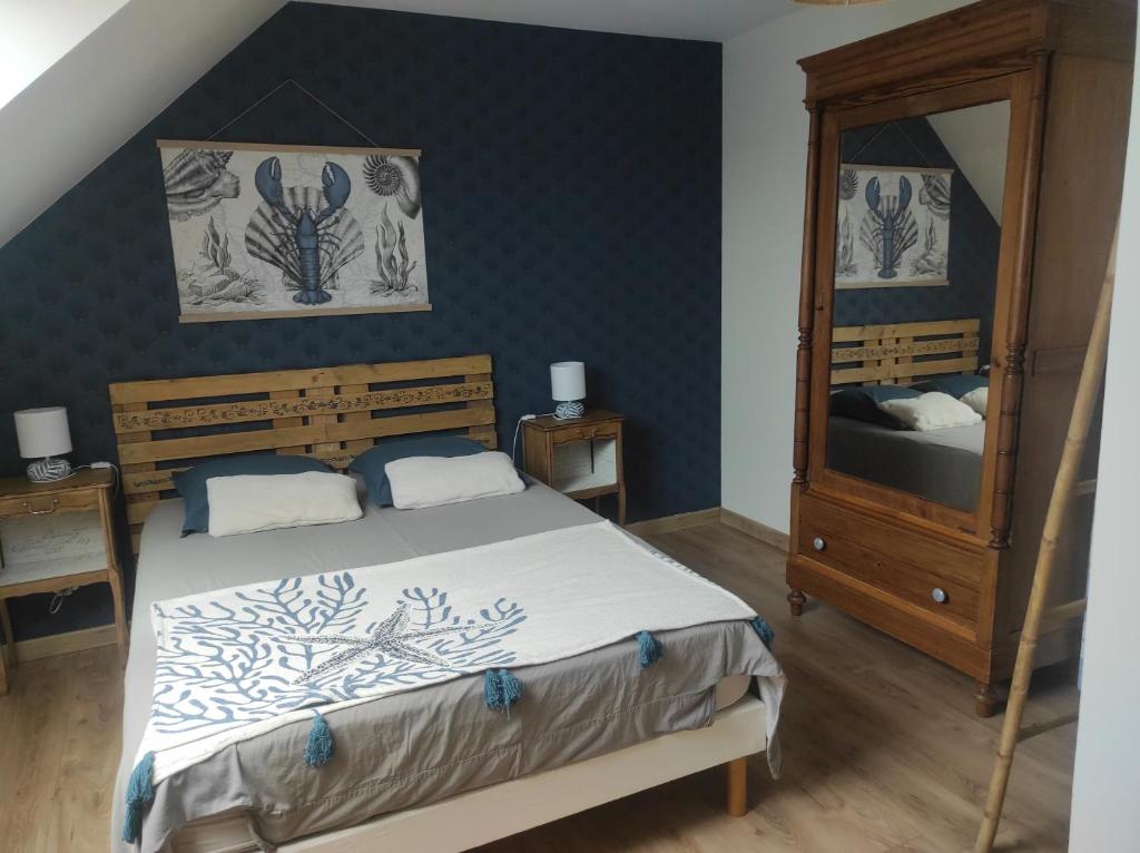 Schlafzimmer mit einem Bett, einer Kommode und einem Spiegel in der Unterkunft Le goéland in Créances