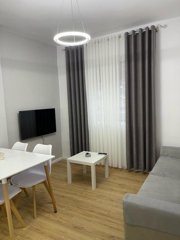 uma sala de estar com um sofá e uma mesa em Beratinus Apartment em Berat