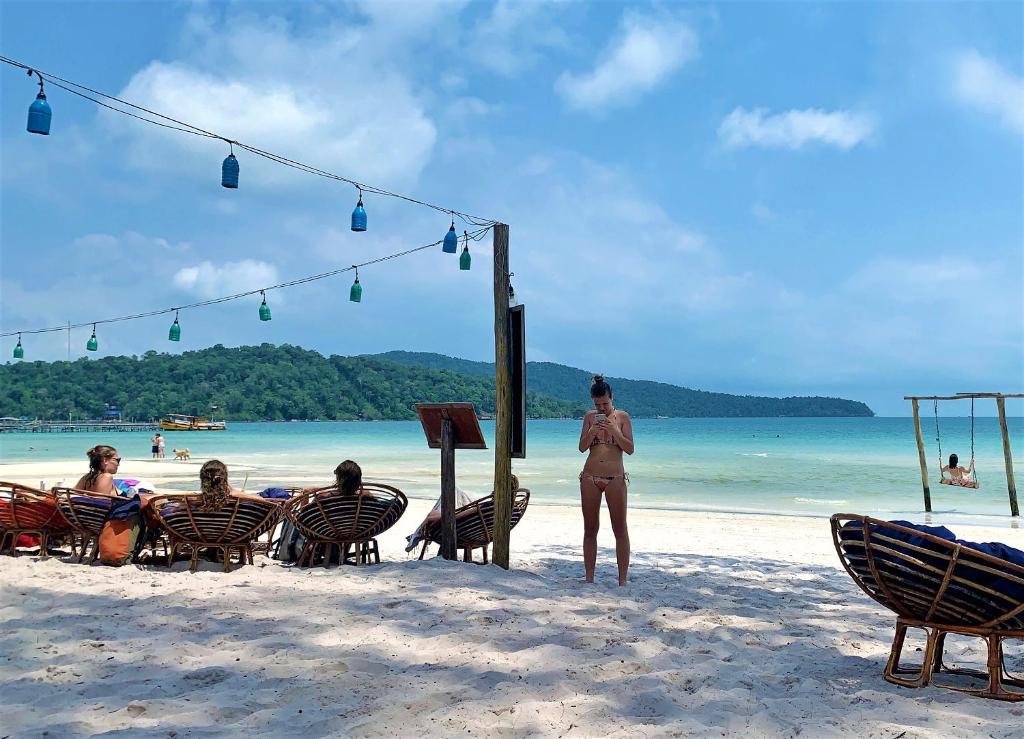 a group of people sitting in chairs on the beach at The Big Easy Koh Rong Samloem in Koh Rong Sanloem