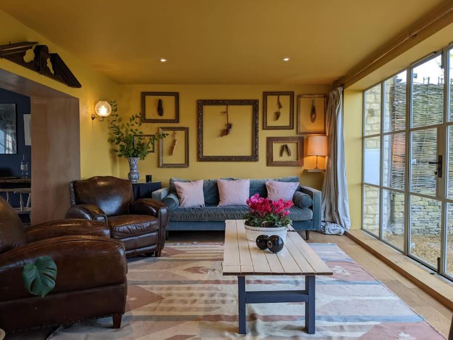 uma sala de estar com um sofá e uma mesa em Stylish 3 bed Cotswold cottage with stunning views em Cheltenham