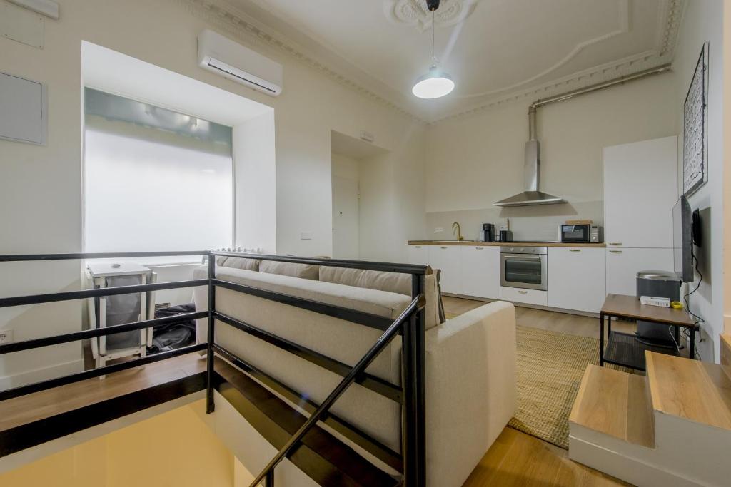 sala de estar con escalera y cocina en Modern Apt & Cool interior design a 20 metros del Retiro en Madrid