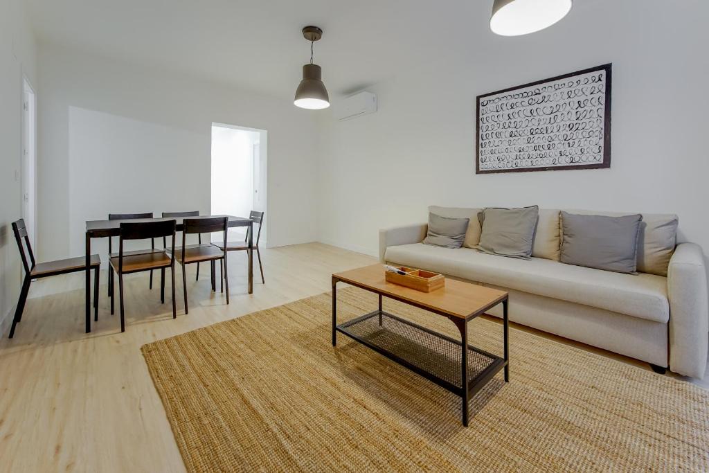 Modern Apt para 6pax en la Plaza de Tirso-Centro في مدريد: غرفة معيشة مع أريكة وطاولة