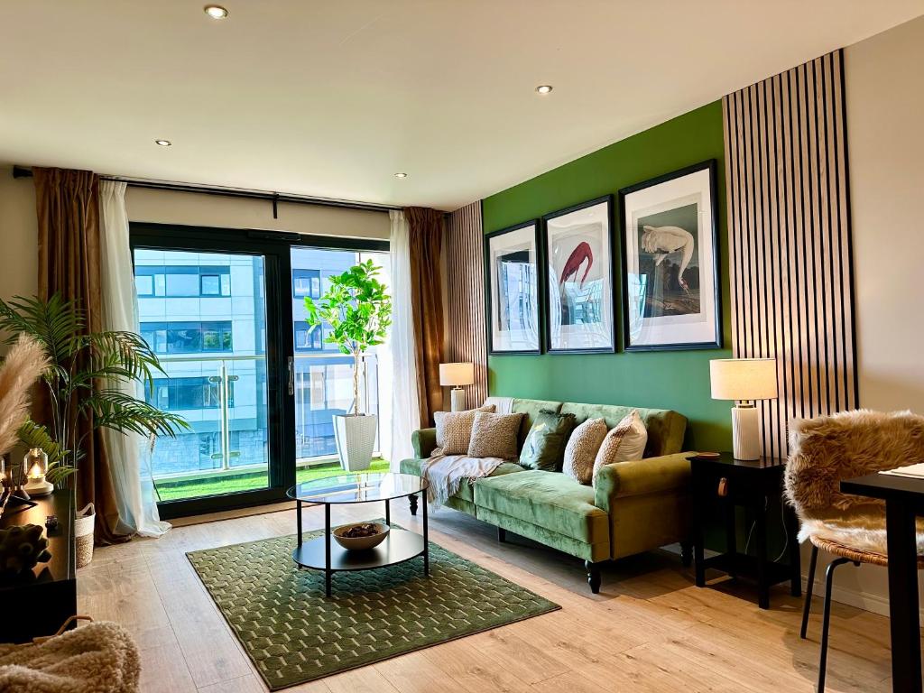 een woonkamer met een bank en een groene muur bij The Snug At Pierson House in Plymouth