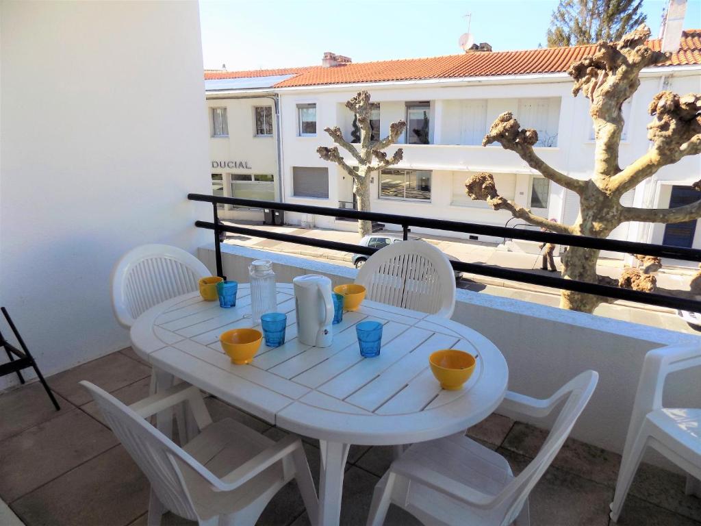 een witte tafel en stoelen op een balkon bij Royan - APPARTEMENT avec EMPLACEMENT IDEAL - terrasse - garage privatif in Royan