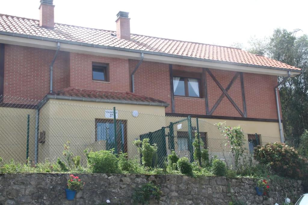 Pesués的住宿－Apartamento en Altos de Pesués，前面有栅栏的红砖房子