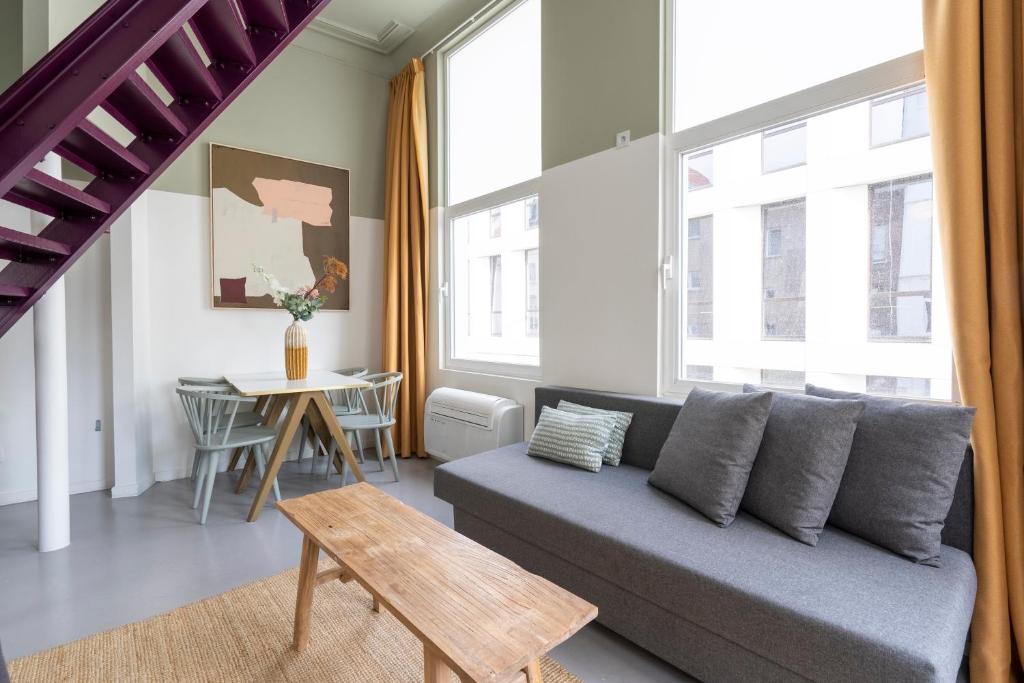 uma sala de estar com um sofá e uma mesa em The Black Pants em Antuérpia
