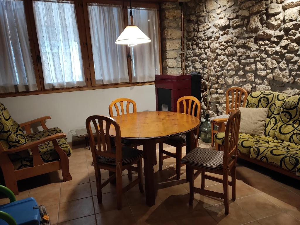 sala de estar con mesa, sillas y sofá en Casa Ramona, en Conques