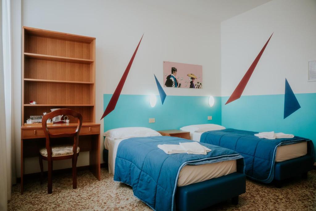um quarto com 2 camas, uma secretária e uma cadeira em Casa Accademia em Veneza
