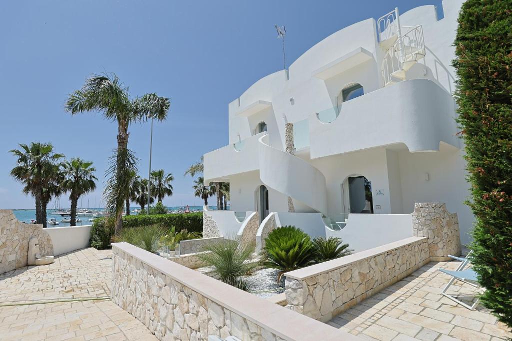 una casa bianca con palme e l'oceano di Villa delle Sirene a Porto Cesareo