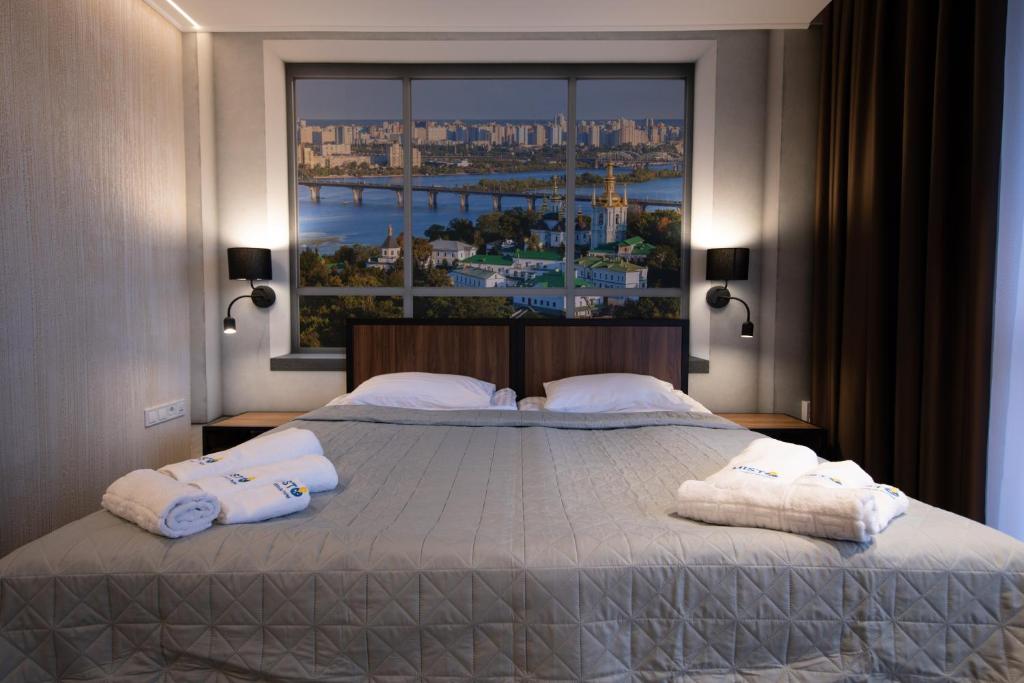 ein Schlafzimmer mit einem großen Bett mit Handtüchern darauf in der Unterkunft MISTO capsule hotel in Kiew