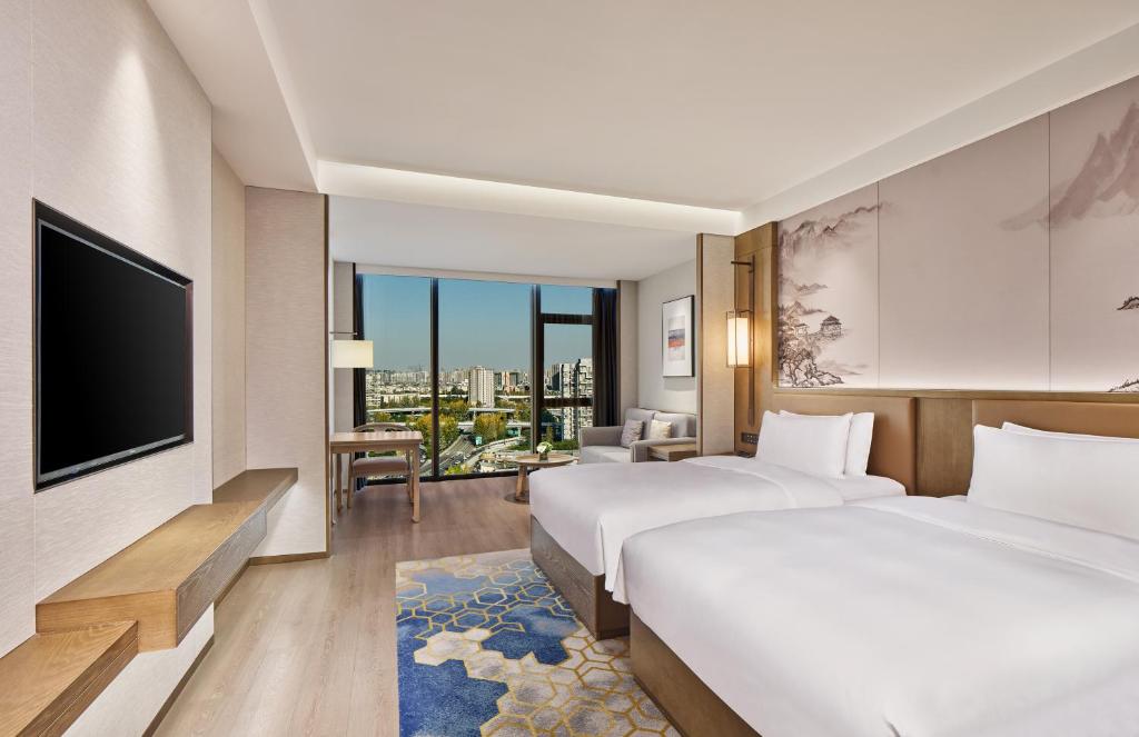 成都市にあるCrowne Plaza Chengdu Wuhou by IHGのベッド2台と薄型テレビ付きのホテルの部屋