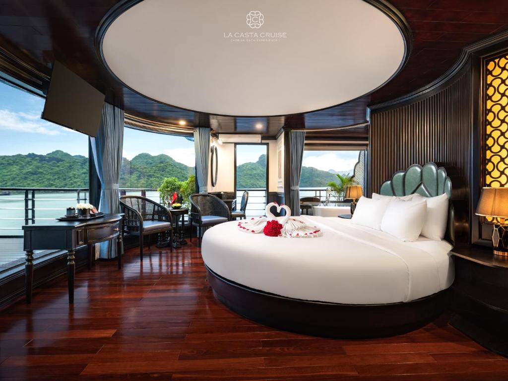 Un dormitorio con una gran cama blanca en una habitación. en La Casta Cruise, en Ha Long