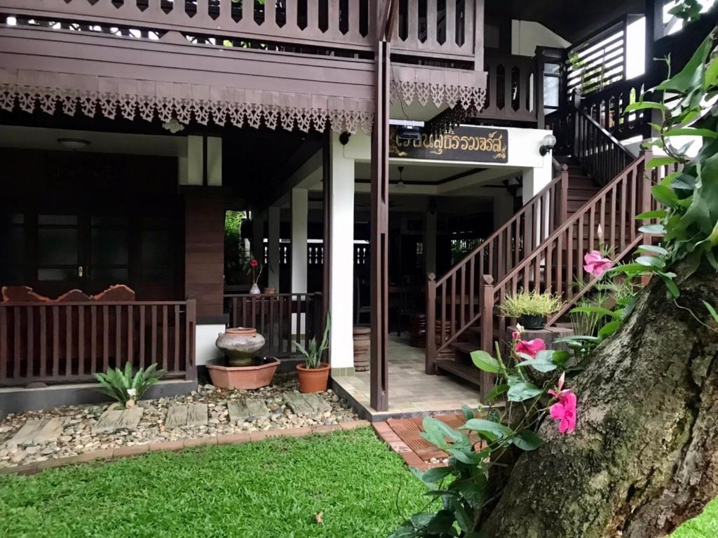 um alpendre frontal de uma casa com plantas e flores em SJ House em Chiang Mai