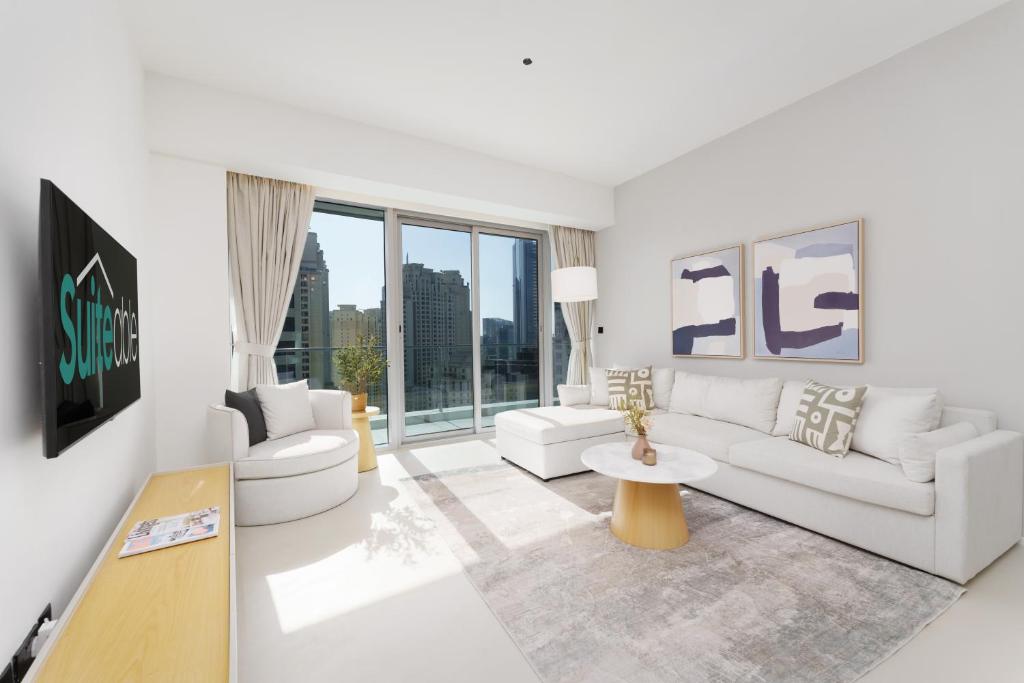 a living room with white furniture and large windows at Lavish Living in Dubai Marina's Finest 2 bedroom in Dubai