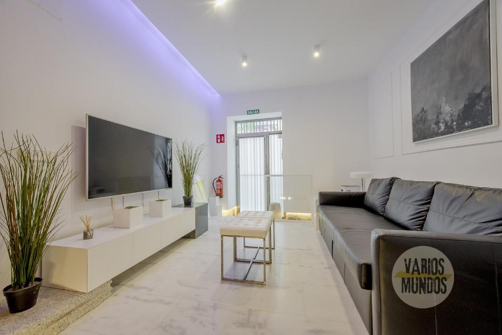a living room with a couch and a tv at Cool Duplex Bajo Apt 7pax cerca de Tirso de Molina in Madrid