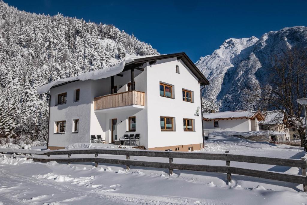 una casa nella neve con montagne sullo sfondo di Haus Zak a Scharnitz