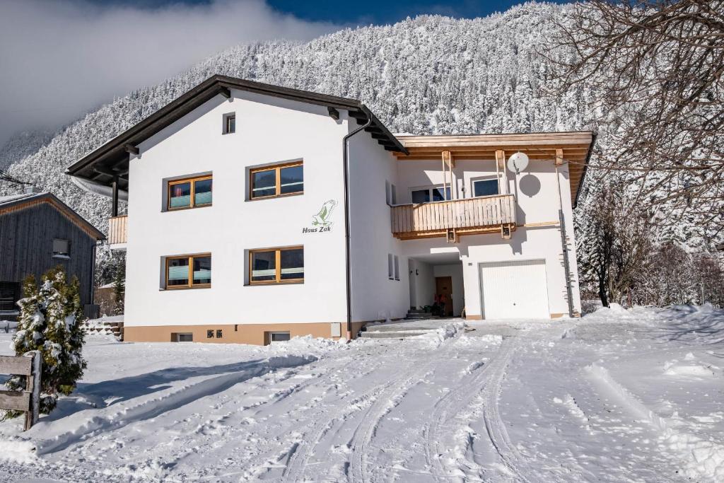 uma casa com varanda na neve em Haus Zak em Scharnitz