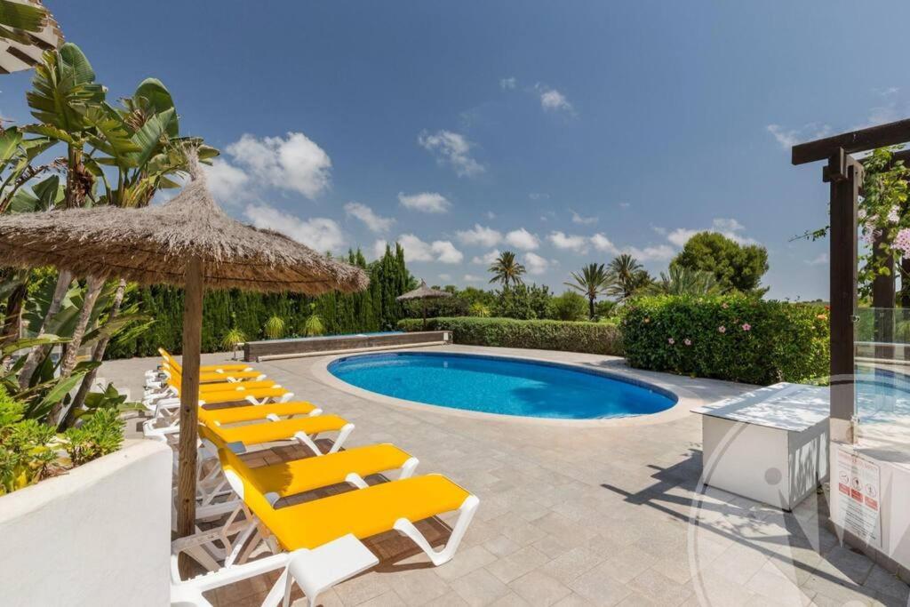 un grupo de sillas con sombrilla y piscina en La Manga Club Resort - Individual Villa 524, en Atamaría
