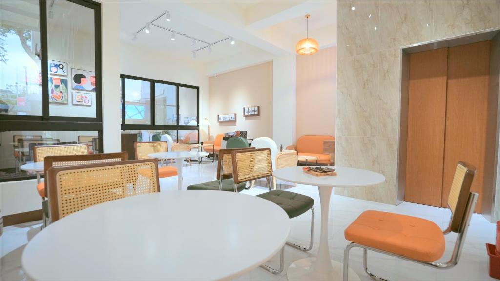 咻咻宿 Xiuxiu 電梯宅 في مدينة تايتونج: غرفة طعام مع طاولات وكراسي وطاولة