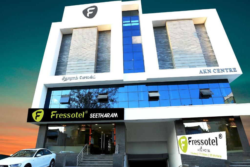 a white car parked in front of a building at Fressotel Seetharam in Coimbatore