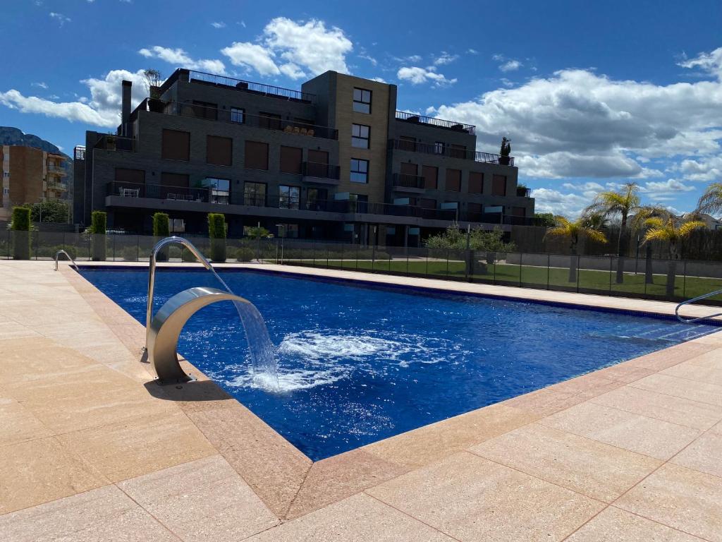 a swimming pool with a fountain in front of a building at Las Lomas Denia I Les Deveses in Denia