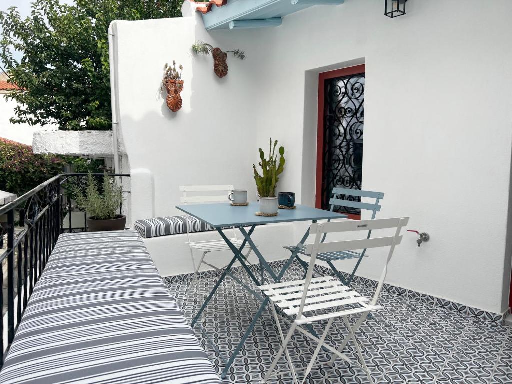 un patio con tavolo blu e sedie sul balcone. di Archipelagos by halu! a Città di Skiathos