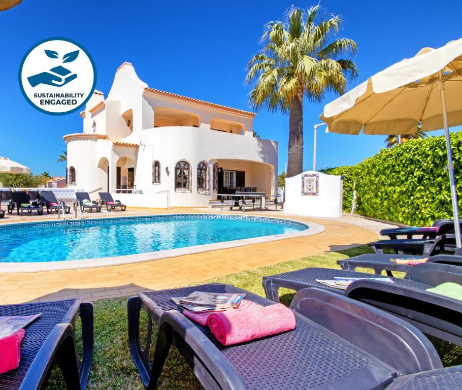 a villa with a swimming pool in front of a house at Villa Morais by Algarve Vacation in Guia
