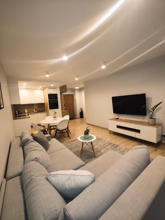 uma sala de estar com um sofá e uma televisão de ecrã plano em Maya's Flats & Resorts 42 - Świętej Barbary em Gdansk